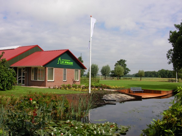 Het bedrijfspand van De Wyngaerd aan de Lytse Wyngaerden in Langezwaag, met vijver en vlonder ervoor